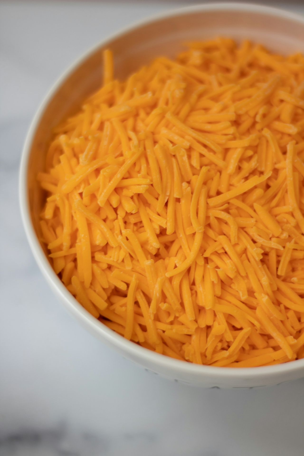 a bowl of cheddar grated cheese
